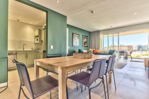 a kitchen and dining room with a wooden table and chairs at Luxury three Bedroom Apartment - fully furnished and equipped in Cape Town