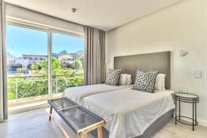 a bedroom with two beds and a large window at Luxury three Bedroom Apartment - fully furnished and equipped in Cape Town