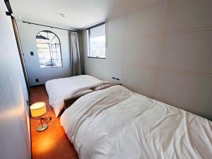 a room with two beds and a window at KIIIYA cafe&hostel in Azumino