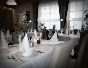 une table à manger avec des nappes et des serviettes blanches dans l'établissement Gasthof Weissenbach, à Strobl