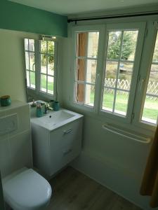a bathroom with a toilet and a sink and windows at Le Moment Normand in Émalleville +121 photos