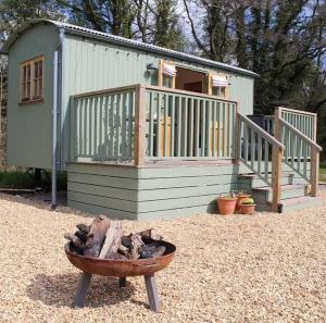 a tiny house with a deck and a fire pit at Kingfisher in Chirk
