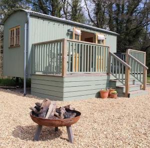 una casa pequeña con terraza y fogata en Kingfisher en Chirk