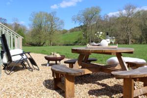 einen Picknicktisch und einen Stuhl im Hof in der Unterkunft Kingfisher in Chirk