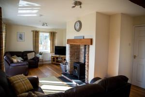 a living room with a couch and a fireplace at Lower Pentre in Llanddewi Ystradenny