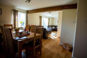 a dining room and living room with a table and chairs at Lower Pentre in Llanddewi Ystradenny