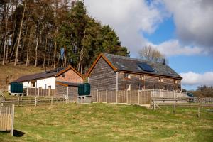 un fienile su una collina vicino a una recinzione di Lower Pentre a Llanddewi Ystradenny