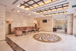 a lobby with couches and a television and a rug at Al Hidayah Towers Hotel in Mecca