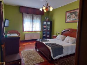 1 dormitorio con 1 cama con paredes verdes y TV en LEIKERENEA. Amplio apartamento en Bermeo, en Bermeo