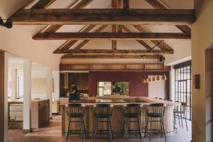 a kitchen with wooden ceilings and bar stools at Hampton Manor in Hampton in Arden
