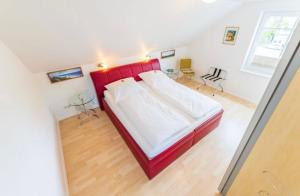 een slaapkamer met een rood bed in een kamer bij Villa Judith App. 3 Silbermöwe in Binz