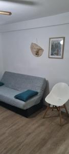 a bedroom with a bed and a white chair at Apartamento 309 frente al mar en Alcossebre in Alcossebre