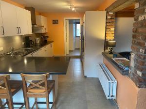a kitchen with a counter and some chairs in it at Ferme Hurlet in Stavelot