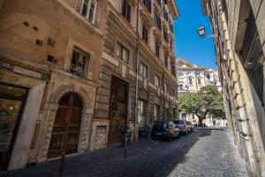 un callejón con coches estacionados en el lateral de un edificio en Cartari Apartment en Roma