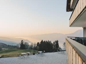 balcón con mesas y sillas y vistas a las montañas en Auszeit-Hotel Z Aeschiried en Aeschi