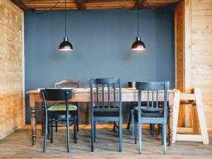 een eetkamer met een tafel en stoelen tegen een blauwe muur bij Auszeit-Hotel Z Aeschiried in Aeschi