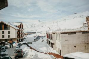 a snow covered street with buildings and a ski slope at Ultra Lux in New Gudauri in Gudauri