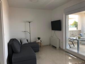 un soggiorno con un divano e una TV di Apartments Kovacev a Zara (Zadar)