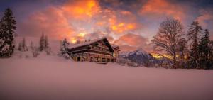 un lodge en la nieve frente a una montaña en Auszeit-Hotel Z Aeschiried, en Aeschi