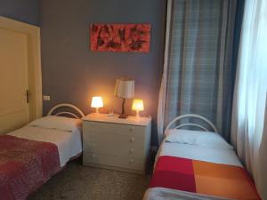 a bedroom with two beds and a lamp on a dresser at Exclusive Ca Quadri Apartments in Venice
