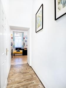 a hallway with white walls and a floor with wooden floors at Gogol Studio Apartment in Budapest