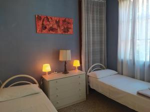 a bedroom with two beds and a dresser with two lamps at Exclusive Ca Quadri Apartments in Venice