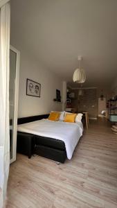 1 dormitorio con 1 cama grande con almohadas amarillas en Teodósio-Zona Central- Ar condicionado-Perto Praias, en Setúbal