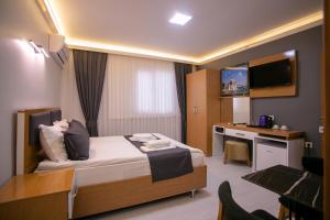 um quarto de hotel com uma cama e uma secretária em BLAU GRÜN İSTANBUL OTEL em Istambul