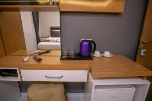 een bureau met een koffiezetapparaat in een kamer bij BLAU GRÜN İSTANBUL OTEL in Istanbul