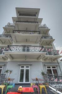 a building with colorful tables and chairs in front of it at Arenaa Deluxe Hotel in Melaka