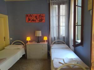 a bedroom with two beds and a dresser with two lamps at Exclusive Ca Quadri Apartments in Venice