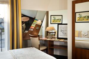 Cette chambre comprend un bureau et un lit. dans l'établissement Grand Hotel des Balcons, à Paris