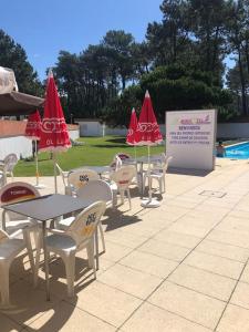 a group of tables and chairs with umbrellas at Cabedelo Beach Loft in Darque