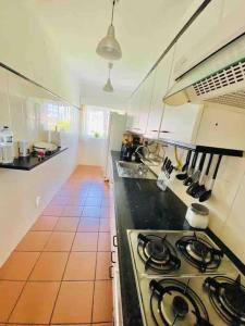 a kitchen with a stove top oven in a room at Cabedelo Beach Loft in Darque