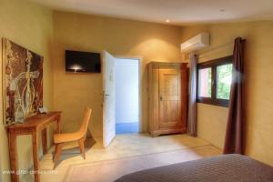 a bedroom with a bed and a chair and a door at Chambre d'hôtes couvent d'Alando in Alando