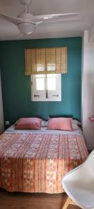 a bedroom with a bed with pink pillows and a window at Apartamento 309 frente al mar en Alcossebre in Alcossebre