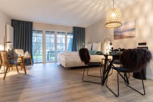 a bedroom with a bed and a table and chairs at Beach Lodge Beach Lodge Appartement 1 in Böhl