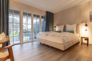 a bedroom with a large bed and a large window at Beach Lodge Beach Lodge Appartement 1 in Böhl