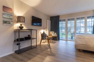 a bedroom with a bed and a table and a chair at Beach Lodge Beach Lodge Appartement 1 in Böhl