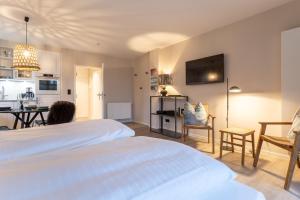 a person sitting at a bed in a room at Beach Lodge Beach Lodge Appartement 1 in Böhl +11 photos