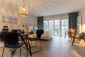 ein Wohnzimmer mit einem Bett und einem Tisch und Stühlen in der Unterkunft Beach Lodge Beach Lodge Appartement 6 in Sankt Peter-Ording