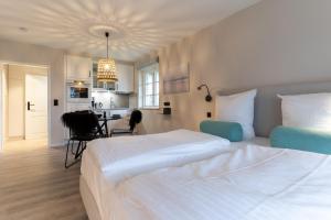 ein Hotelzimmer mit zwei Betten und einer Küche in der Unterkunft Beach Lodge Beach Lodge Appartement 6 in Sankt Peter-Ording