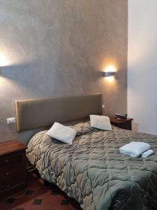 una camera da letto con un grande letto con due cuscini sopra di Il Verrocchio a Firenze