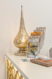 a shelf with a lamp and books on it at Hotel Reina Aixa in Cogollos de Guadix