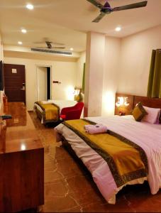 Habitación de hotel con 2 camas y ventilador de techo. en Namaste Benares Varanasi en Varanasi