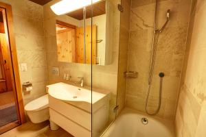 a bathroom with a sink and a shower and a toilet at Chesa Munteratsch 1 1 2-Zimmerwohnung 609 Typ D in Silvaplana +67 photos