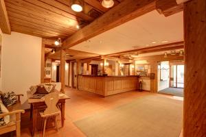 a large living room with wooden ceilings and a table at Chesa Munteratsch 2-Zimmmerwohnung 205 Typ E in Silvaplana