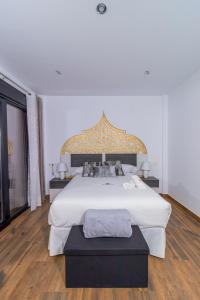 um quarto com uma grande cama branca e uma grande janela em Hotel Reina Aixa em Cogollos de Guadix