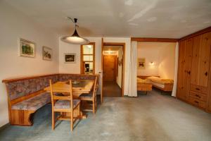 a living room with a table and a bedroom at Chesa Munteratsch 1 1 2-Zimmerwohnung 309 Typ C in Silvaplana