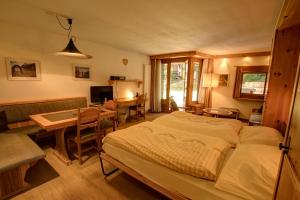 a bedroom with a bed and a table and a desk at Chesa Munteratsch 1-Zimmerwohnung 107 Typ B in Silvaplana